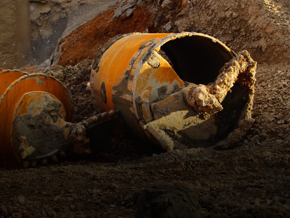 Image shows dirty, damaged and discarded construction equipment